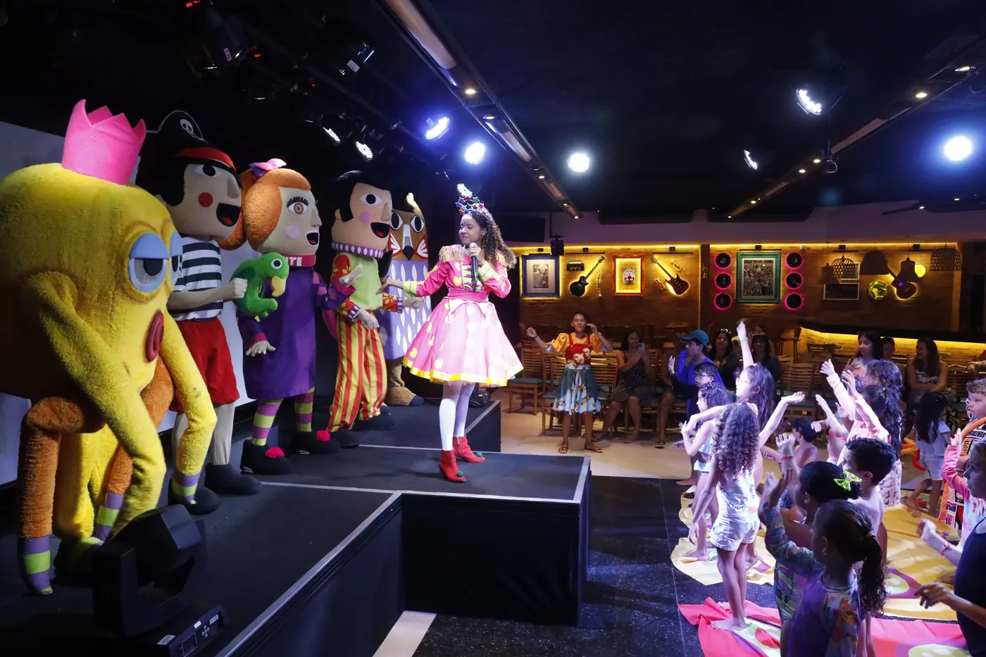 Crianças assistindo show com personagens na Vila Brincante